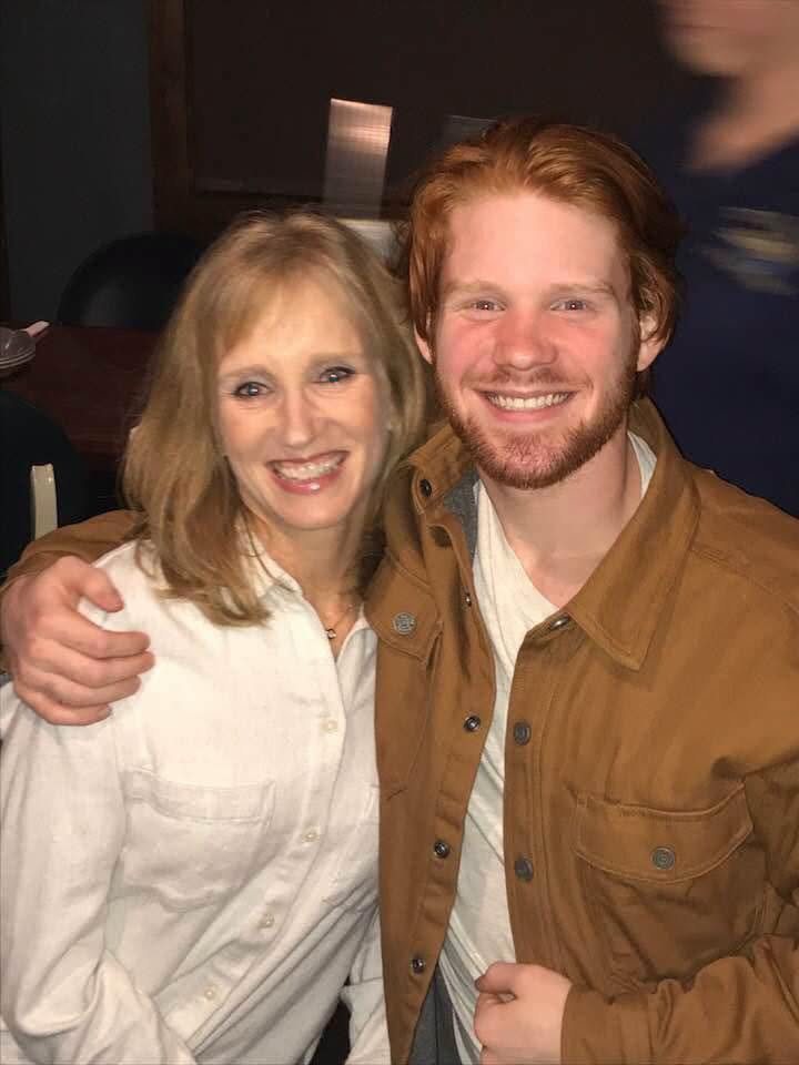 Max Cochran smiling with his arm around his mom, Kelly
